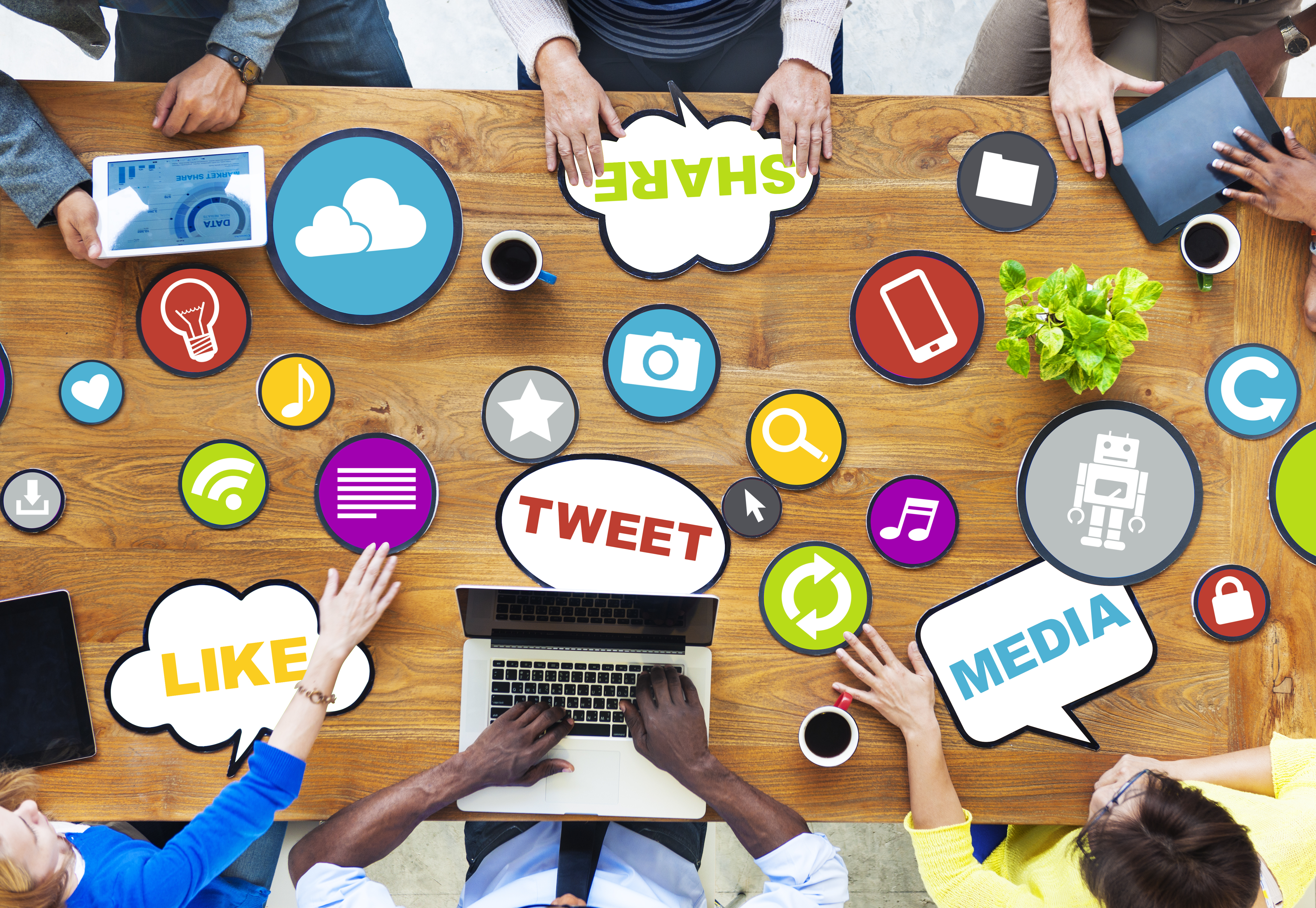 People gather around a table sharing idea around social media